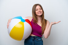 Young Caucasian Woman Holding Beach Ball Isolated On White Background Extending Hands To The Side For Inviting To Come