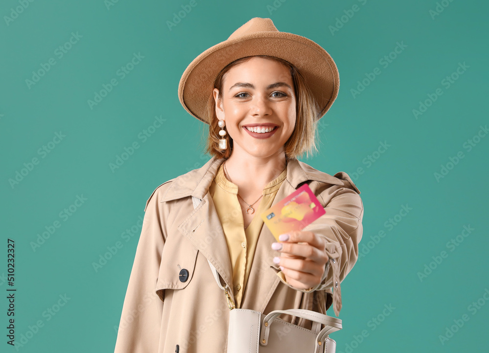 Young woman with credit card on green background. Online shopping