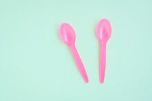 Pink Plastic Spoons On Green Background