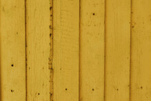 Texture Of Old Wooden Painted Yellow Planks. Old Wooden Fence With Yellow Paint. Boards With Nails