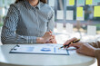 © crizzystudio - Analysis, Discussion, Asian woman economist and marketer pointing to a financial data sheet to plan, Negotiation