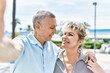 © Krakenimages.com - Middle age caucasian couple of husband and wife together on a sunny day outdoors. Smiling happy in love hugging taking a selfie picture