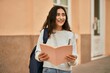 © Krakenimages.com - Young middle east student girl smiling happy reading book at the city.