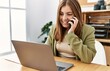 © Krakenimages.com - Young hispanic woman talking on the smartphone working at office