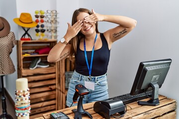 Sticker - Young brunette woman holding banner with open text at retail shop covering eyes with hands smiling cheerful and funny. blind concept.