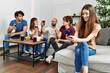 © Krakenimages.com - Group of young friends having party sitting on the sofa at home. Woman smiling happy using smartphone at home.