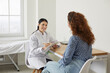 © Studio Romantic - Doctor at modern clinic or medical office giving consultation to patient. Female physician talking to young woman, asking questions, listening carefully, holding clipboard and writing down symptoms