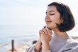 © Krakenimages.com - Young woman smiling confident praying at seaside