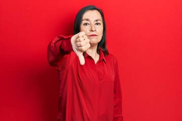 Sticker - Middle age hispanic woman wearing casual clothes looking unhappy and angry showing rejection and negative with thumbs down gesture. bad expression.