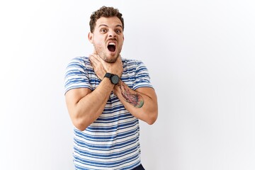 Wall Mural - Handsome young man standing over isolated background shouting suffocate because painful strangle. health problem. asphyxiate and suicide concept.