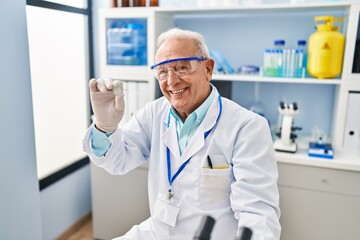 Sticker - Senior man wearing scientist uniform holding sample at laboratory