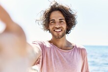Young Hispanic Man Smiling Happy Make Selfie By The Camera Standing At The Beach.