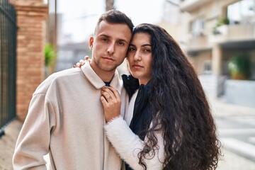 Wall Mural - Man and woman couple standing together with relaxed expression at street