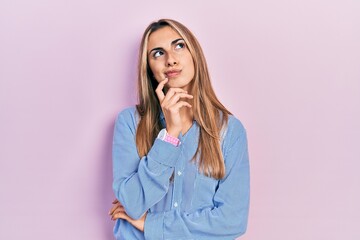 Sticker - Beautiful hispanic woman wearing casual shirt thinking concentrated about doubt with finger on chin and looking up wondering