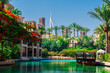 5 June 2022 - Dubai, UAE: Souk Madinat Jumeriah waterway with green landscape and Burj Al-Arab
