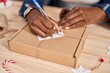 © Krakenimages.com - African american woman ecommerce business worker writing on package at office