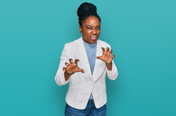 Wall Mural - Young african american woman wearing business clothes smiling funny doing claw gesture as cat, aggressive and sexy expression