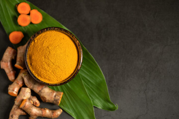 Canvas Print - Flat lay (top view) of Turmeric powder and fresh turmeric (curcumin) on a black background, Used for cooking and as herbal medicine, copy space.