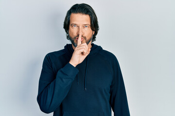 Poster - Middle age caucasian man wearing casual sweatshirt asking to be quiet with finger on lips. silence and secret concept.