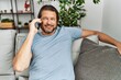 © Krakenimages.com - Middle age caucasian man smiling confident talking on the smartphone at home