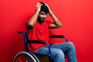 Poster - Arab man with beard sitting on wheelchair suffering from headache desperate and stressed because pain and migraine. hands on head.