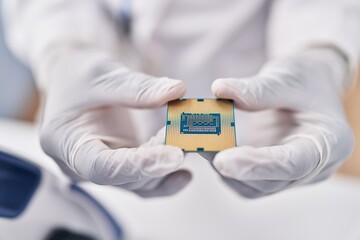 Poster - African american woman wearing scientist uniform holding cpu microchip at laboratory