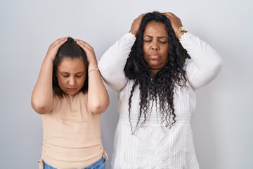 Poster - Mother and young daughter standing over white background suffering from headache desperate and stressed because pain and migraine. hands on head.