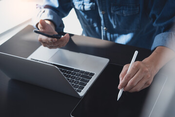 Canvas Print - Closeup, business man using digital tablet and mobile phone, working on laptop computer on office table