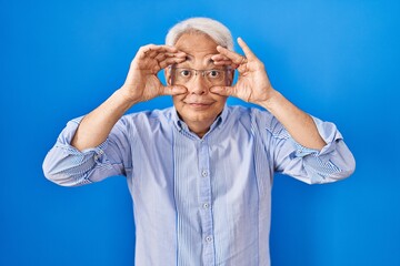 Sticker - Hispanic senior man wearing glasses trying to open eyes with fingers, sleepy and tired for morning fatigue