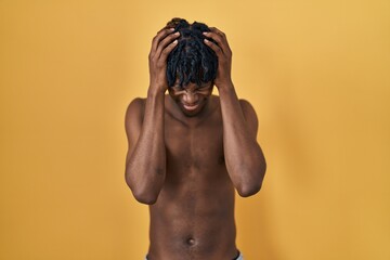 Sticker - Young african man with dreadlocks standing shirtless suffering from headache desperate and stressed because pain and migraine. hands on head.