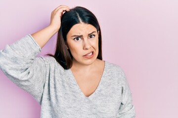 Poster - Young hispanic woman wearing casual clothes confuse and wonder about question. uncertain with doubt, thinking with hand on head. pensive concept.