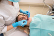 © Tania - Dentist-hygienist conducts a teeth cleaning procedure for a girl in a dental clinic. Removal of tartar.