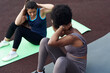 © etonastenka - Cheerful young diverse female friends doing ab crunches on stadium in the park - friends together doing exercise outdoors