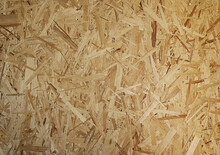 OSB Boards Are Made Of Brown Wood Chips, Sanded Into A Wooden Background. Top View Of OSB Wood Veneer, Dense, Seamless Surfaces.