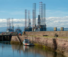 Wall Mural - North Sea oil Rigs across an old stone harbour 