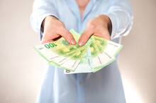 Hands Giving 100 Euro Banknotes Isolated On Light Gray Background