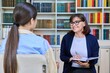 © Valerii Honcharuk - Female teacher talking to teenage student in the library