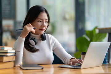 study abroad happy asian girl laughing While doing homework, make a video call abroad using a friend's internet connection. business women use computers to analyze financial data