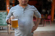 © EmmaStock - Young man holding a glass of beer and is it true that drinking beer makes you fat?