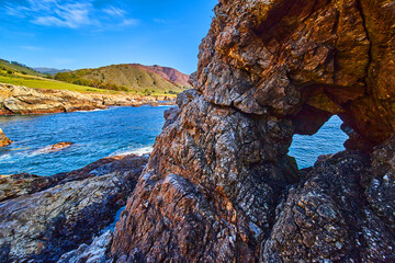 Rock cave by west coast with ocean waves