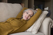 © fizkes - Beautiful middle-aged woman lying on couch at home smiling staring at camera looking untroubled feels happy enjoy weekend leisure alone at modern home. Holidays, carefree retired life, tenant concept