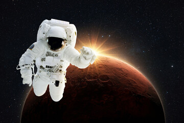 Poster - New spaceman flies in gravity in outer space on a backgrounds of the amazing red planet Mars with orange dawn rays in space. Astronaut Journey to the Planet Mars Concept