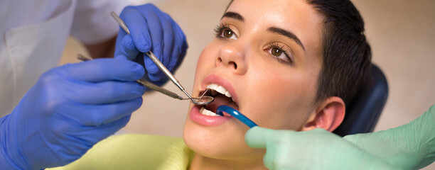 young woman checking her teeth at the modern dentist clinic