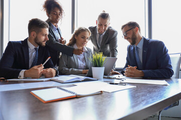 Wall Mural - Group of young modern people in formalwear smiling and discussing something while working in the modern office