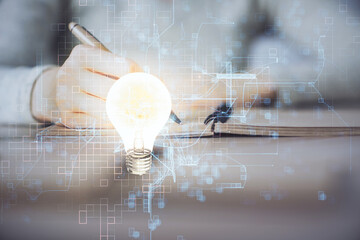 Aufkleber - bulb hologram over hands taking notes background. concept of idea. double exposure