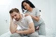 Woman in love massaging shoulders of her upset life partner
