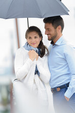 Lovers Walking In Rain With An Umbrella