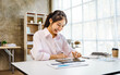 © makibestphoto - Beautiful Asian woman happy working at her desk in the office.
