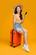 ready to travel ,asian smiling cheerful female woman casual cloth pull luggage bag prepare to new abroad journey travel studio shot on yellow background,joyful asia woman summer vacation tourism
