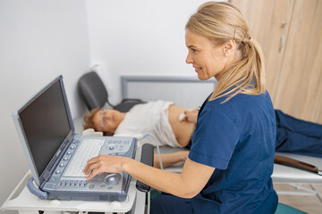 Wall Mural - Doctor ultrasound examine female patient abdomen at hospital. Prenatal diagnosis center